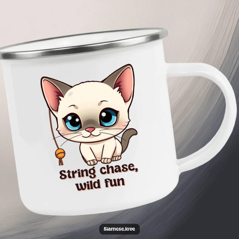 Funny camping mug featuring a kawaii Siamese cat with wide blue eyes, playfully batting at a string. Durable and cute drinkware.