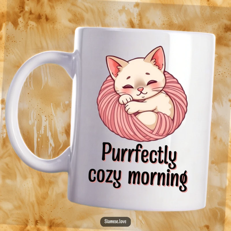 Funny Siamese cat mug showing a content feline curled up asleep inside a soft ball of yarn, exuding peace.