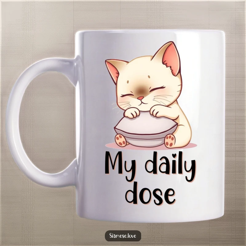Funny Siamese cat mug featuring a cute kawaii kitty nuzzling a small cushion with ultimate contentment and a gentle purr.