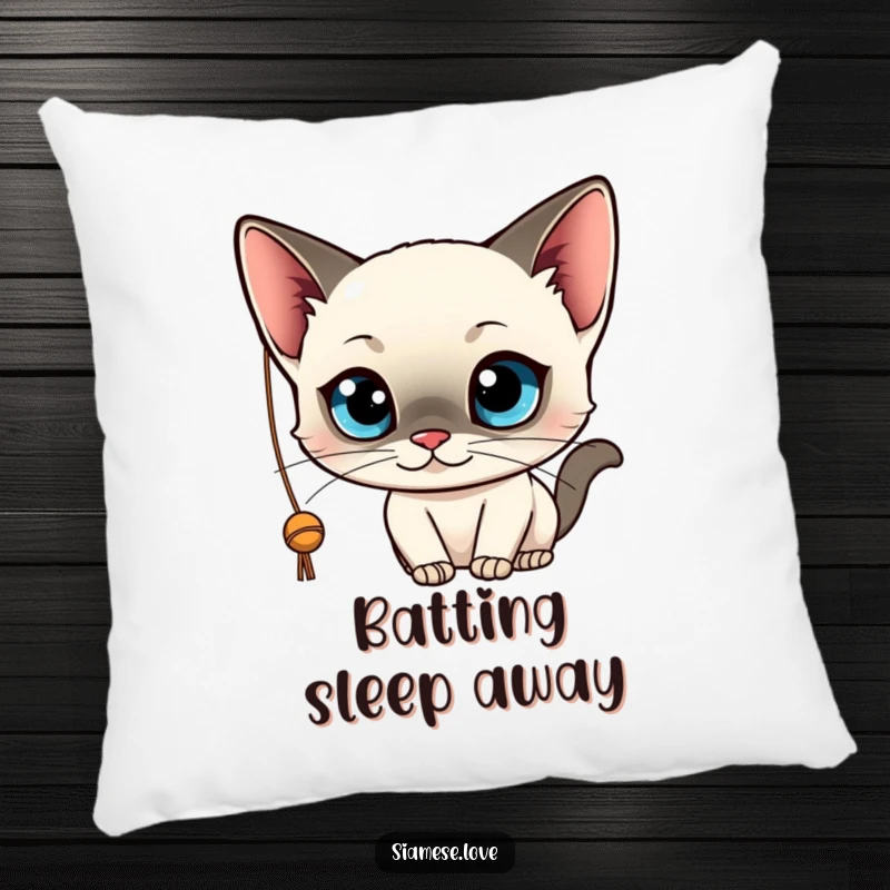 Funny decorative pillow featuring a kawaii Siamese cat with big blue eyes, playfully batting at a string. Soft and cute.