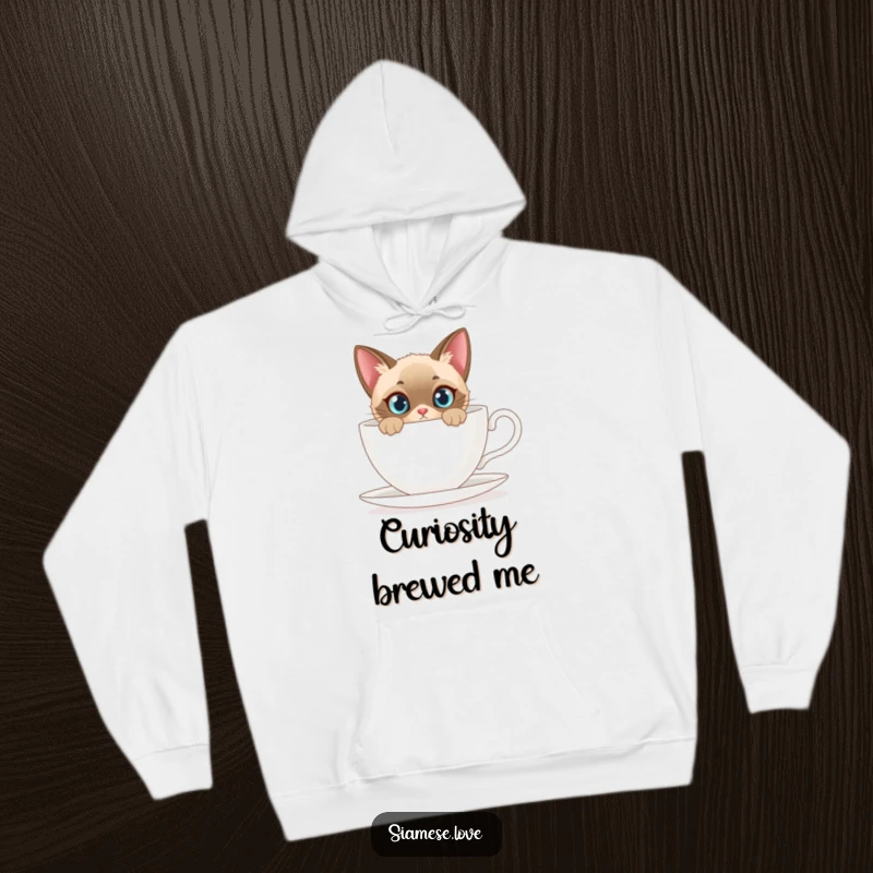 Funny hoodie with a curious Siamese cat peeking from behind a giant teacup, perfect for cozy feline fun.