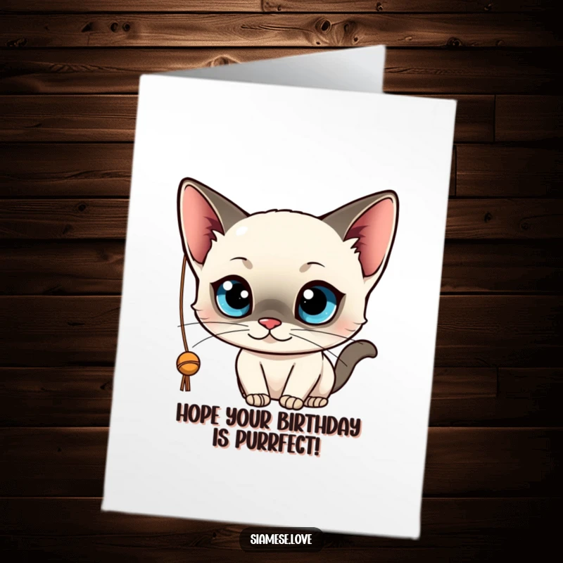 Funny Free Printable Birthday Card: Kawaii Siamese cat with blue eyes playfully batting at a string, celebrating.