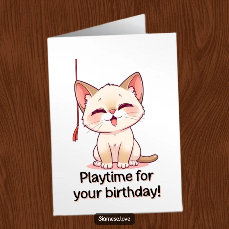 Funny Free Printable Birthday Card: A Siamese cat playfully batting at a dangling string with a mischievous glint.