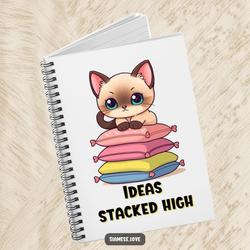 Funny notebook cover featuring a Siamese cat delicately perching on a stack of colorful cushions, for taking notes.
