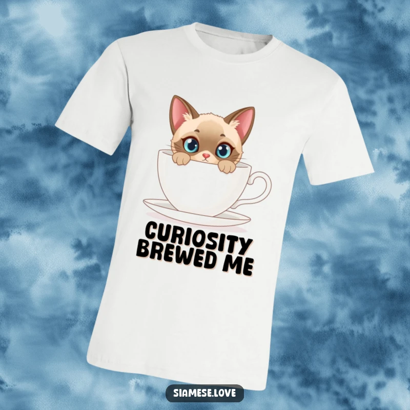 Funny t-shirt featuring a Siamese cat with a curious expression hiding and peeking from behind a comically large teacup.