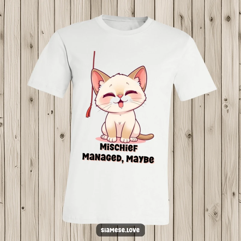 Funny T-Shirt showcasing a playful Siamese cat with mischievous intent, batting at a dangling string, embodying feline fun.