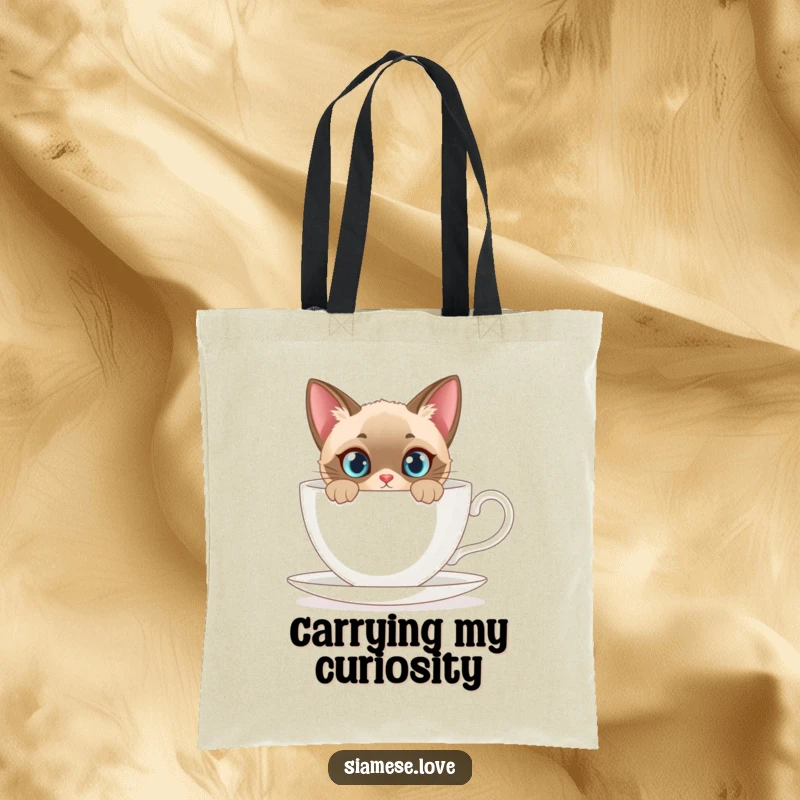 Funny tote bag depicting a curious Siamese cat peeking from behind a giant teacup, ideal for carrying daily items.
